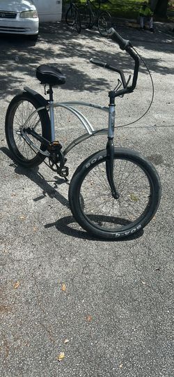 silver 3G Bikes Newport DLX beach cruiser features a patented curved tripod aluminum frame, an internal 3-speed hub, and 26-inch wheels with wide tire