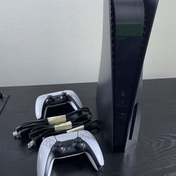 blacked out PlayStation 5 + 2 controllers