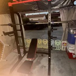 Weider Pro Lifting Rack with Olympic barbell, weight clamps, and weight bench