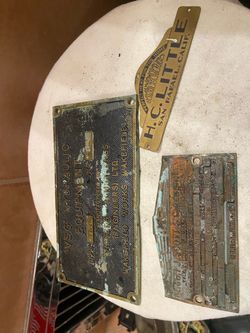 Three antique brass motor emblems