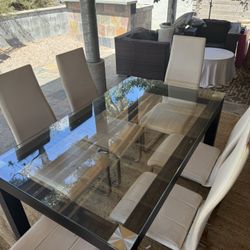 Glass Dining Table With Leather Bound Legs And 6 White Lether Chairs