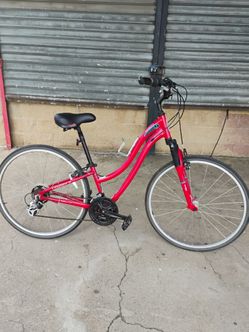 Women's Schwinn Voyageur 21 Hybrid Bike features an aluminum step-through frame, a front suspension fork, and 21-speed Shimano gearing