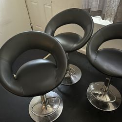Three barstools a deep freezer dining room table with four chairs, a lamp