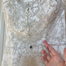 Oleg Cassini White bead embroidered wedding dress Size 10 Ivory mermaid style with a sweetheart neckline

Condition is used with a couple small tears 