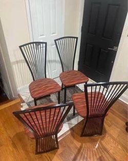 Four black metal dining chairs
