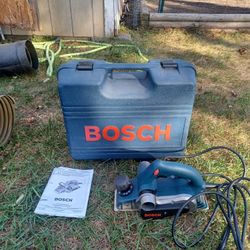 Electric hand-held wood plainer.