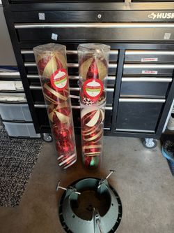 Two sets of red and gold ornaments and a green tree stand.