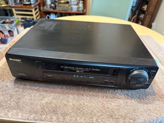 The Sharp VC-H952U 4 Head Hi-Fi Stereo VHS VCR Player is a vintage audio and video device that allows you to play VHS tapes with high-fidelity sound q