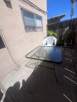 4 plastic chairs and one glass table outdoor