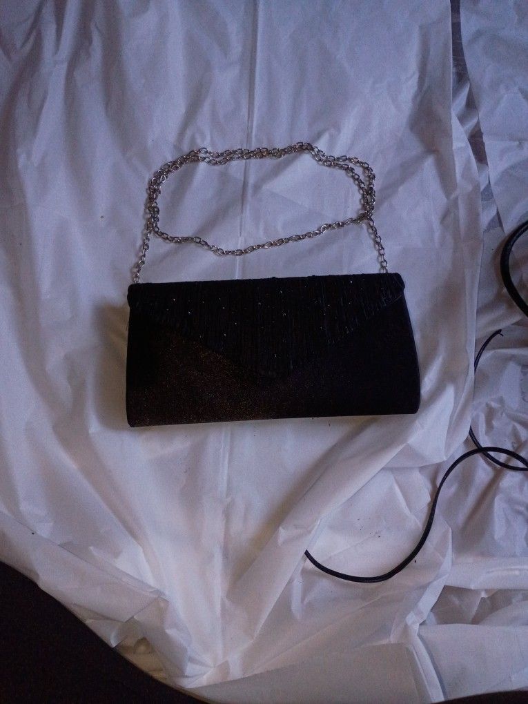 black pleated satin clutch bag with a chain strap.