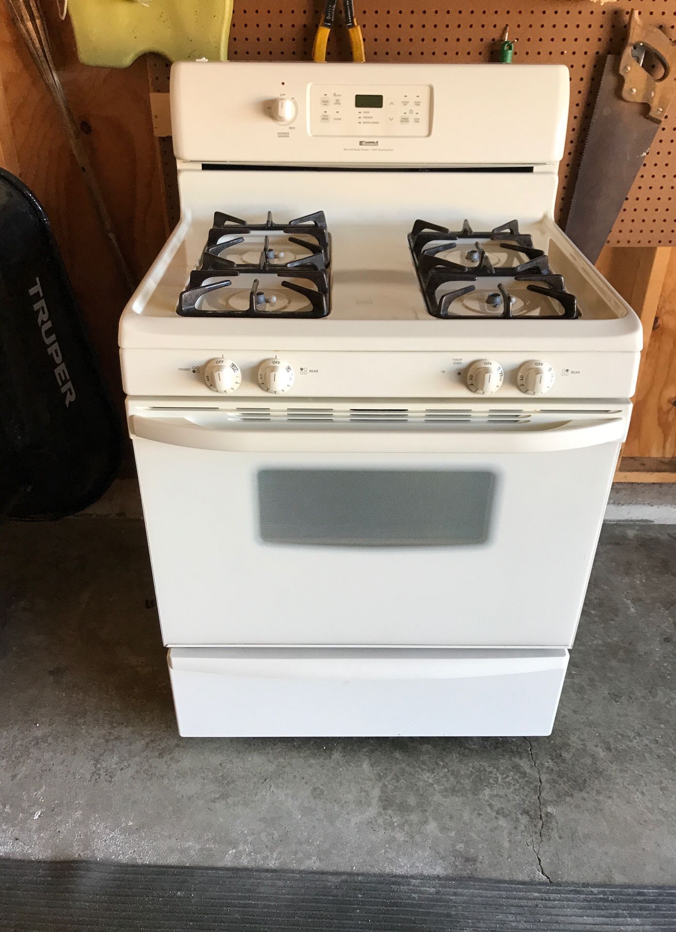 Bisque color 4 burner Kenmore stove with warming drawer and matching backsplash.