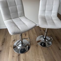 Two white adjustable height barstools