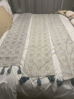 Elegant table runner with intricate patterns and tassels.
