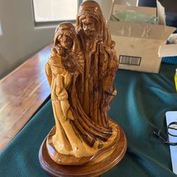 a hand-carved olive wood statue of the Holy Family (Saint Joseph, the Virgin Mary, and the infant Jesus). These