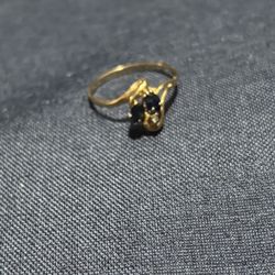 Elegant gold ring with blue sapphires and a diamond.