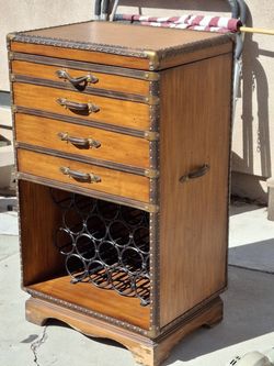 Portable Bar with Wine Rack.  Holds Alcohol also. Good shape . Looks Great  Chipped around bottom.