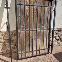 Black metal door gate. .wood panel size .47" inches wide  X. 70 " inches tall.    Incluye. 2 black metal post.  $.  190.