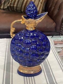 A vintage 1968 Jim Beam cobalt blue grape cluster ceramic decanter.