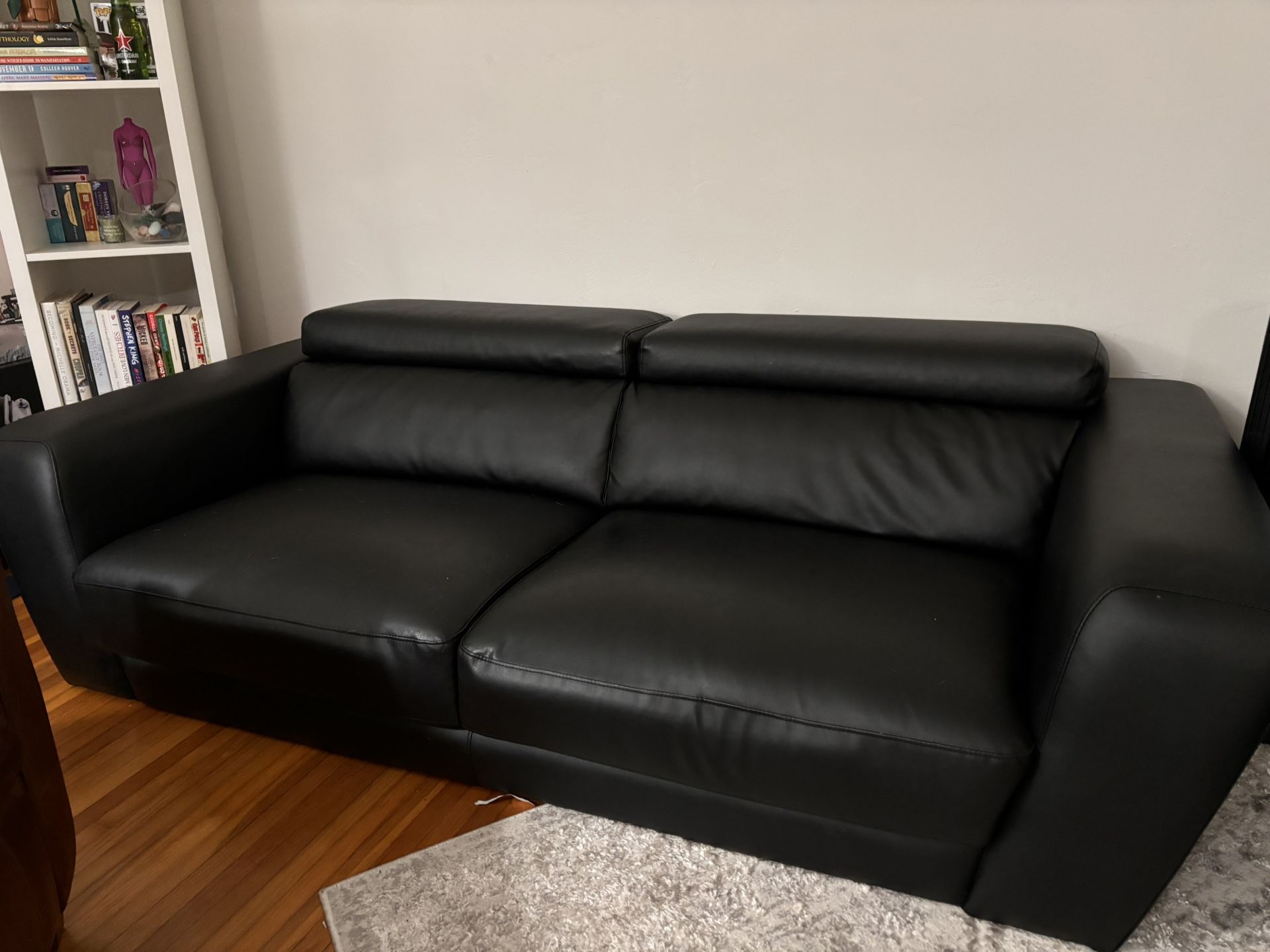 Adjustable Headrest Metal Trim Leather Sofa, a modern piece featuring black genuine leather, built-in adjustable headrests, and distinct metal accent