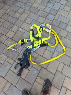full-body harness paired with an attached shock-absorbing tubular lanyard