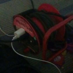heavy-duty retractable extension cable reel used for providing power in workshops, garages, or job sites. 