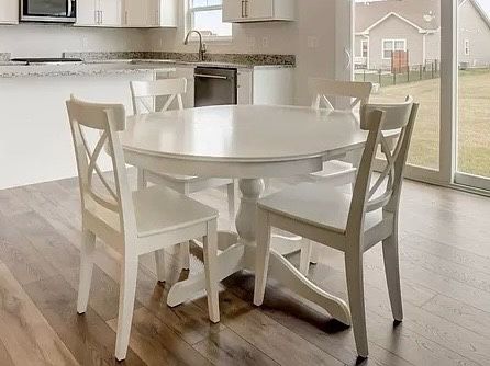 White extendable kitchen table and four white chairs