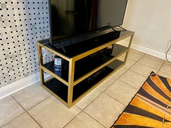 Gold TV stand with black glasses
