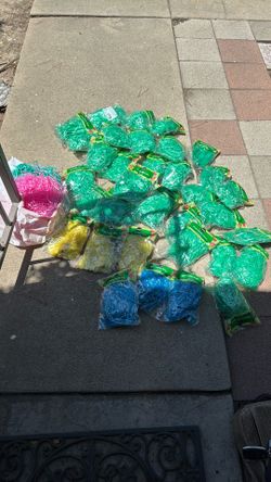 33+ bags of basket grass for Easter or any other holiday party. Colors are green, yellow blue, a big bundle of pink and a big bundle of turquoise.
