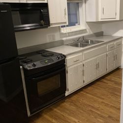 Refrigerator, oven, microwave and upper kitchen cabinets 