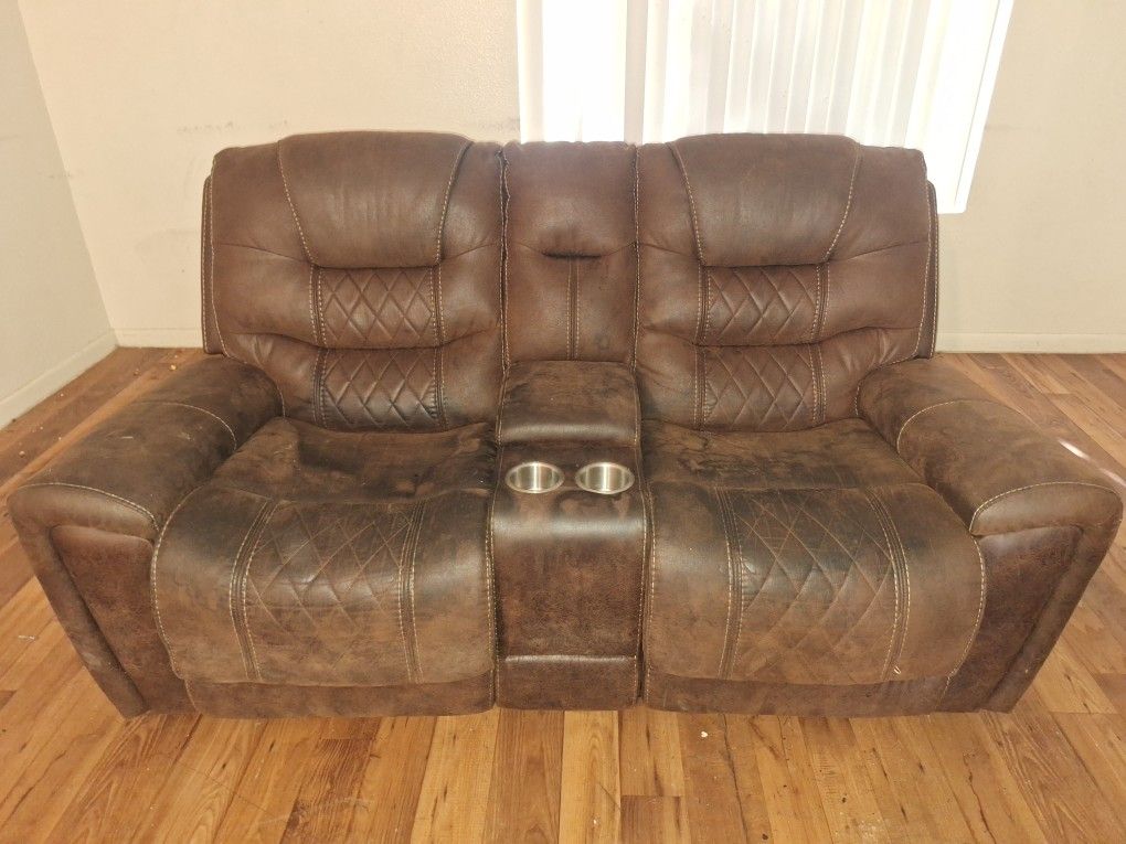 brown reclining loveseat center console and cup holders.