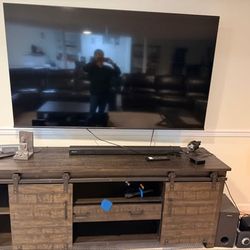 Large Flat Screen TV with Wooden Console and Soundbar