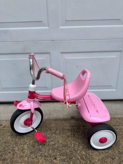 An old-fashioned Radio Flyer pink children's folding tricycle from the United States