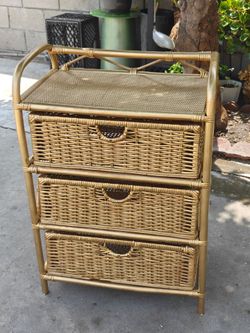vintage-style rattan and bamboo cabinet features a metallic gold finish and three spacious wicker drawers