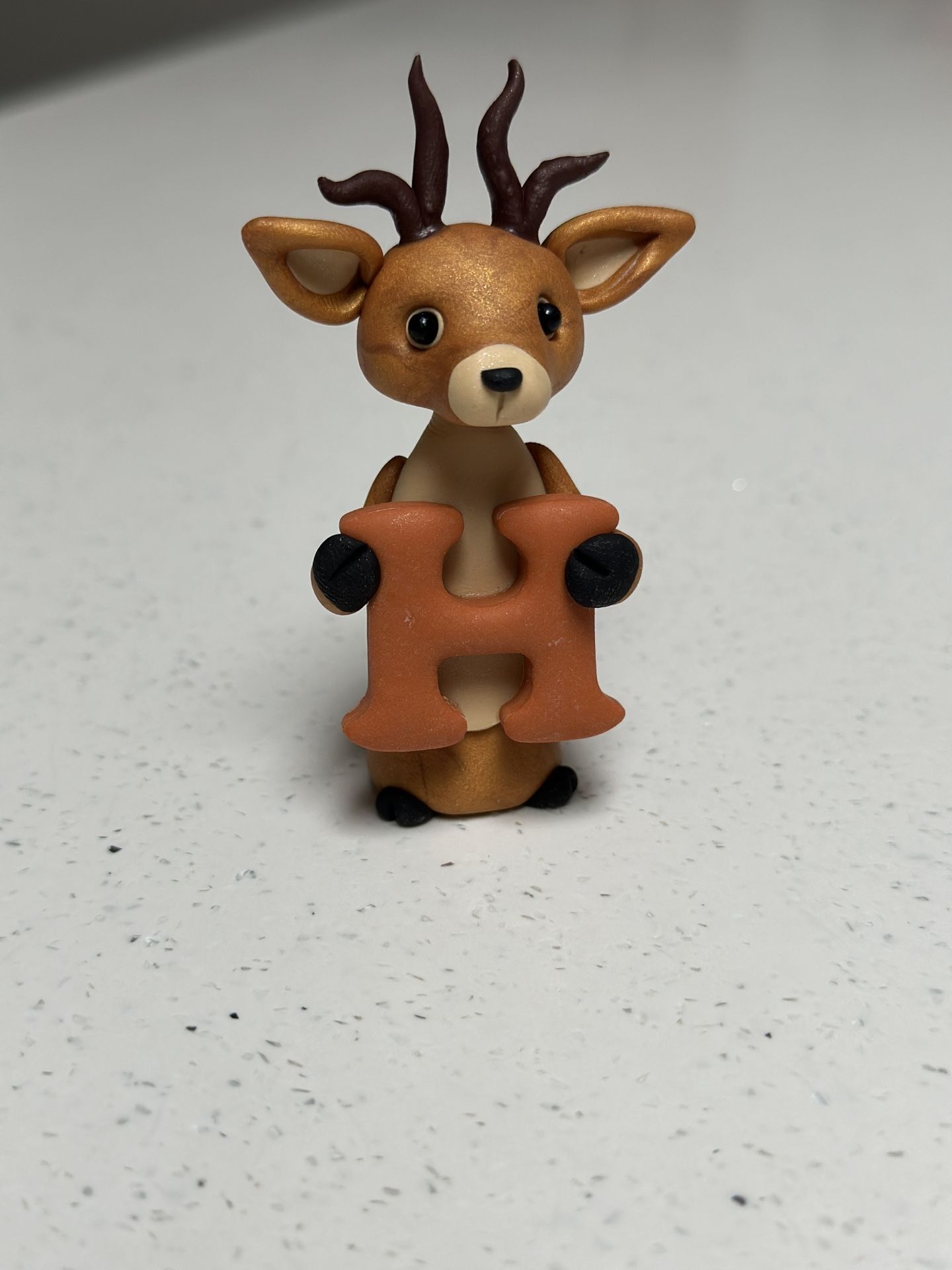 Light Brown Deer Holding “h”