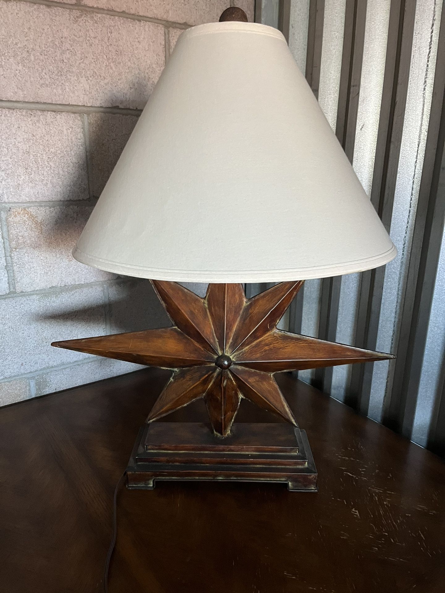 This regent style table lamp features and 8-point star shaped base and contrasting soft back shade.  Product Features : Regent style Materials: Iron, 