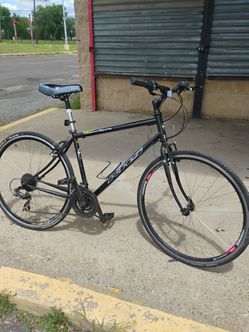 Black KHS Urban Xcape hybrid bicycle with a 700c steel frame and a comfortable plush seat.