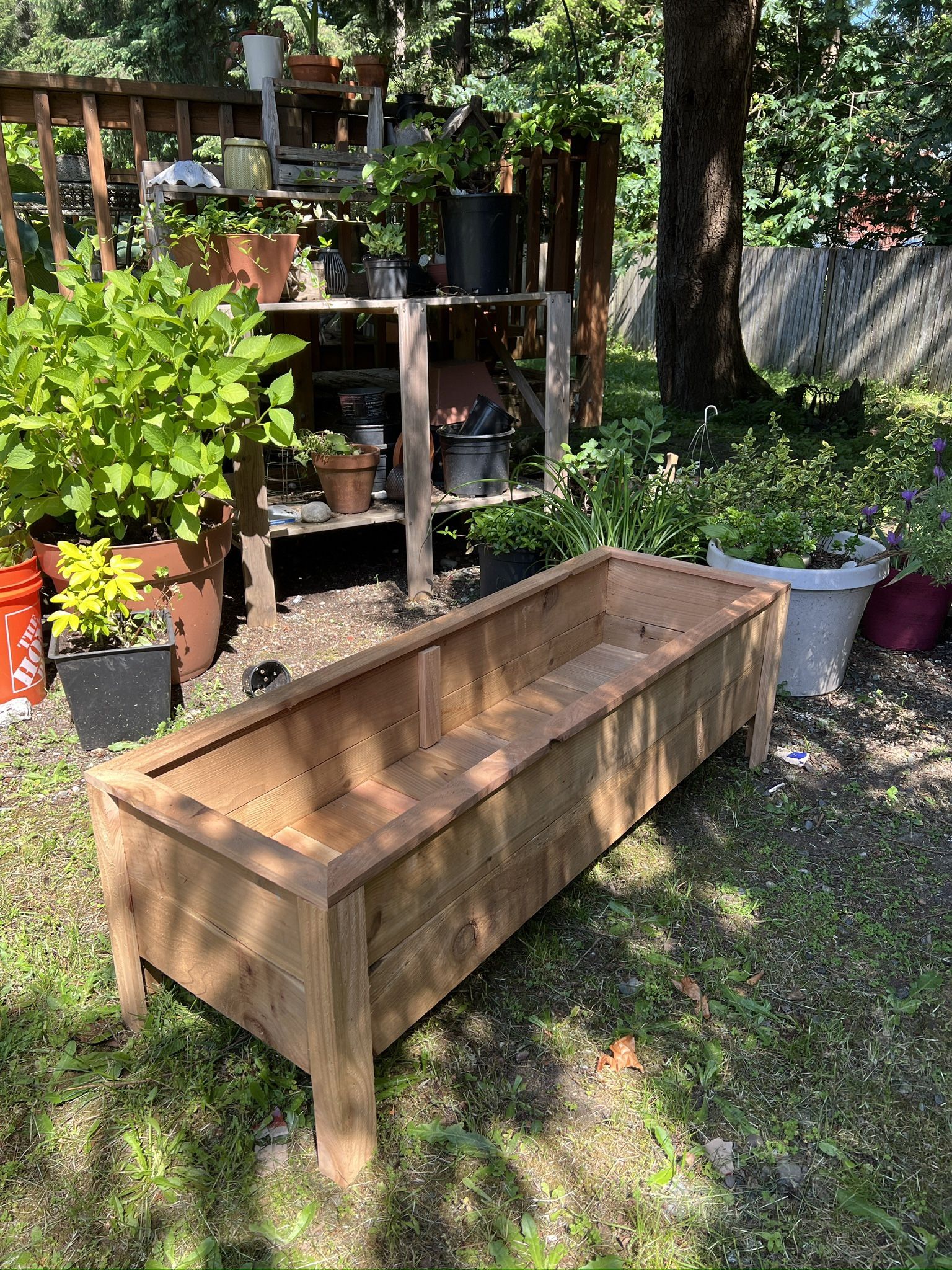 A container made of cedar wood designed for planting flowers & More.