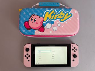 Pink and black Nintendo Switch with case and two docks