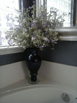 17 inch tall midnight blue glass vase with flowers.