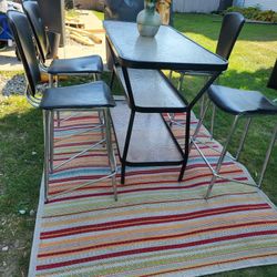 Cute Three Tier Tall Table With Four Stools And A Colorful Rug