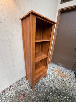 Narrow, solid style wood bookshelf with lower storage drawer