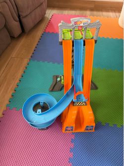 Hot Wheels multi-lane race track has a spiral section. Track is orange and blue.