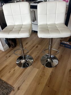 two white adjustable bar stools