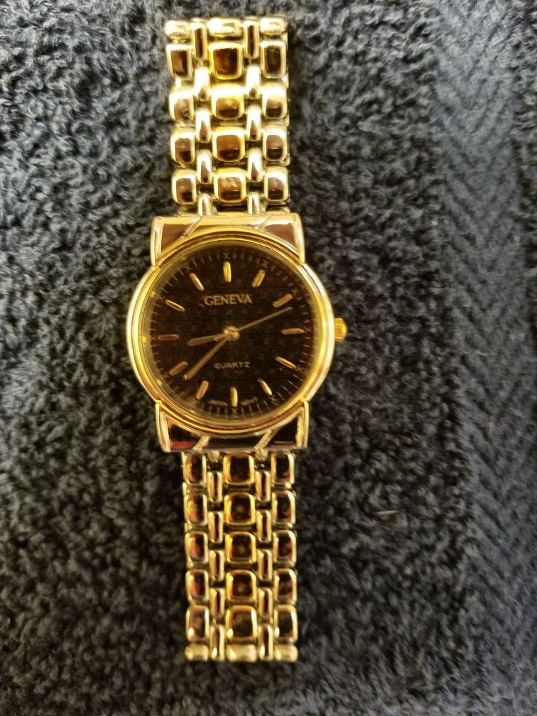 Geneva women’s watch with a silver and gold band and black face.
