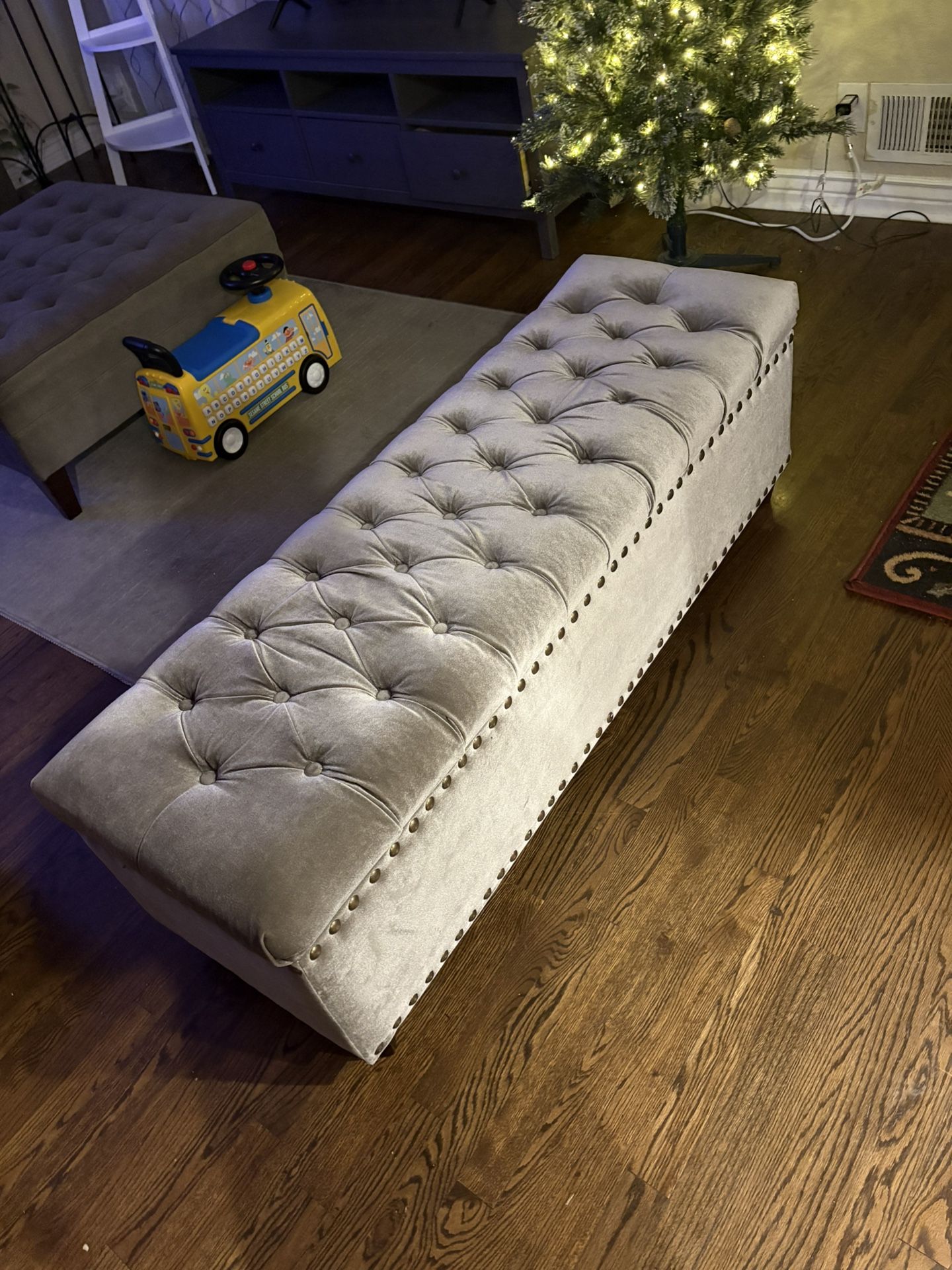 tufted upholstered storage bench featuring nailhead trim details and velvet fabric upholstery.