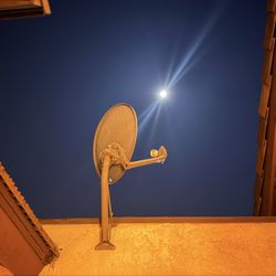 DIRECTV satellite dish mounted on exterior wall/roof.