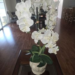 Artificial white Phalaenopsis orchid arrangement in a ceramic pot.