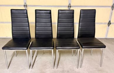 Four black faux leather chairs