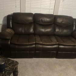 2pc Brown leather Reclining Sofa w/charging port. Includes Decor, Rug and End Tables