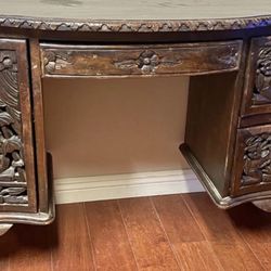 Antique Southeast Asian carved rosewood desk with intricate figural and floral motifs.